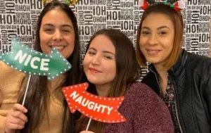 Au Pairs posing with naughty or nice holiday signs.