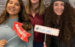 Au Pairs posing with fun signs in the photo booth.