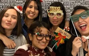 Au Pairs posing with fun holiday props in the photo booth.