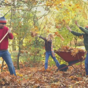 Dad and kids raking leaves