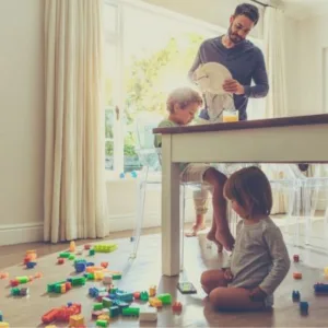 Dad and children cleaning up toys
