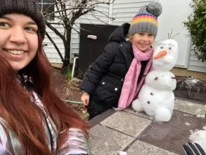 Au Pair Yuliia and her host kid building a snowman