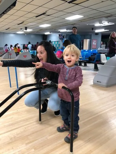 Au Pair and host kid bowling