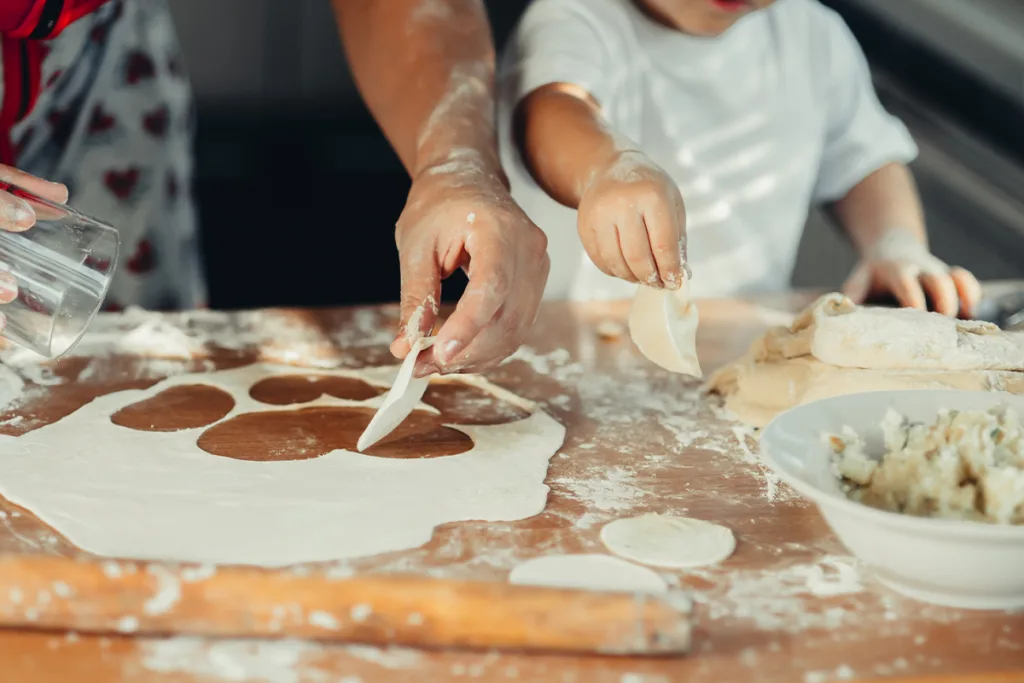 A close-up of an au pair and child engaging in one of the most fun-filled Chinese customs—making winter solstice dumplings.