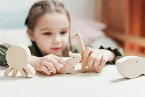 Little girl creatively playing with animal blocks