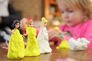 Child making play dough princesses