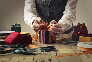 St. Nikolaus wrapping a small gift.