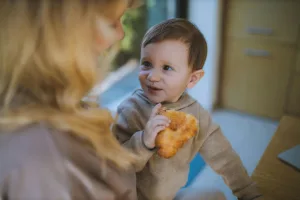 Au Pair and child sharing a croissant