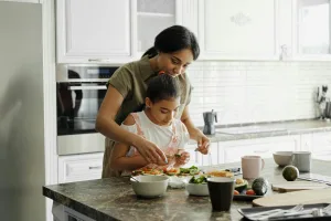 Au Pair and Host Kid cooking together.