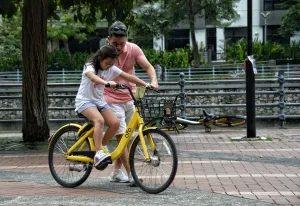 Au Pair teaching child to ride a bike.