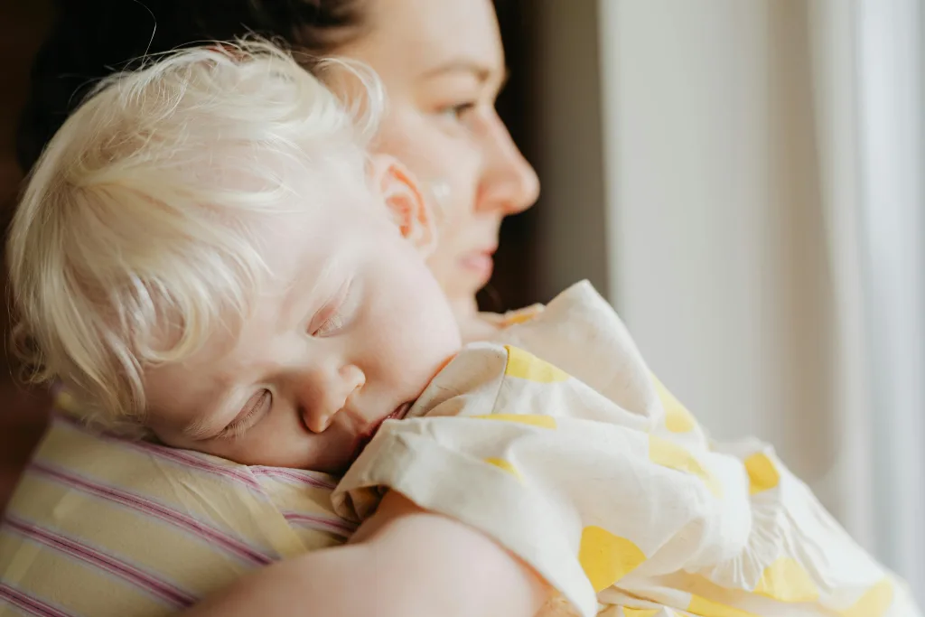 Au Pair holding sleeping toddler