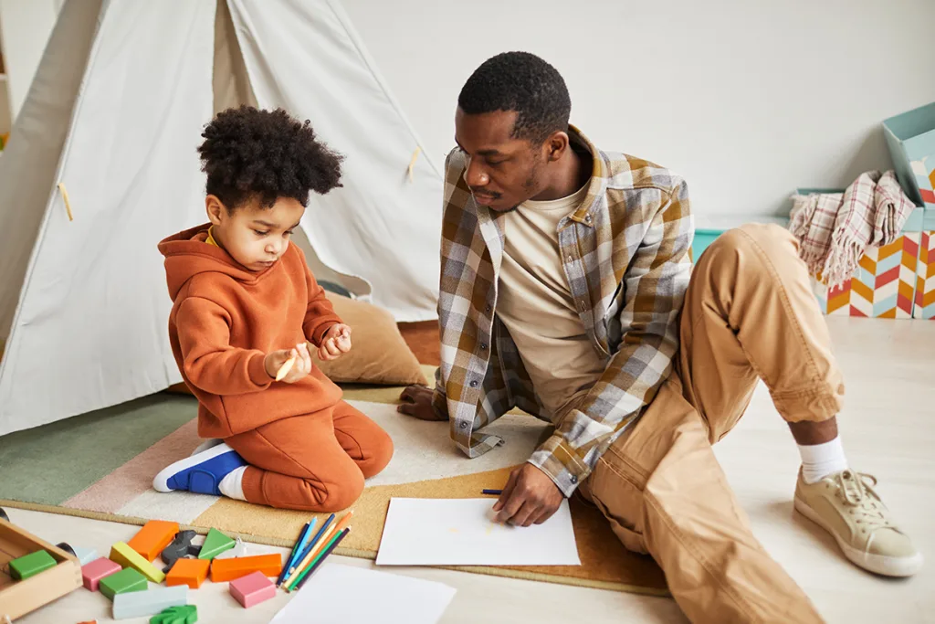 An au pair engaging in a creative activity with a young child, supporting the child's cognitive and fine motor development through play.